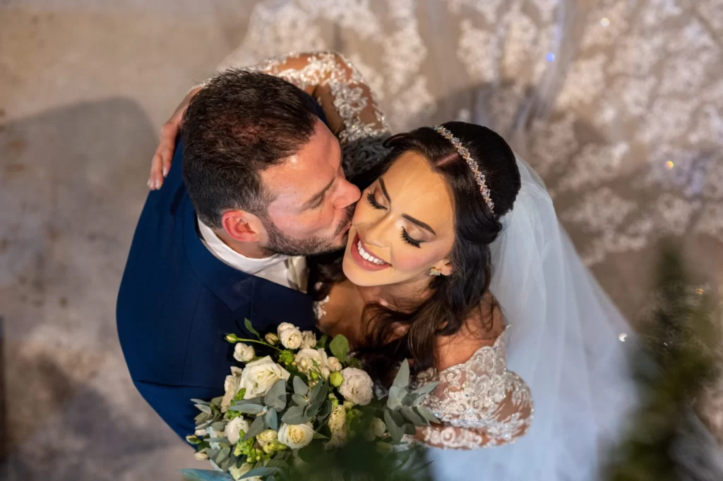 Noivo beijando bochecha da noivaNoivos em first touch pré cerimônia de casamento - As 23 fotos de casamento que você precisa tirar